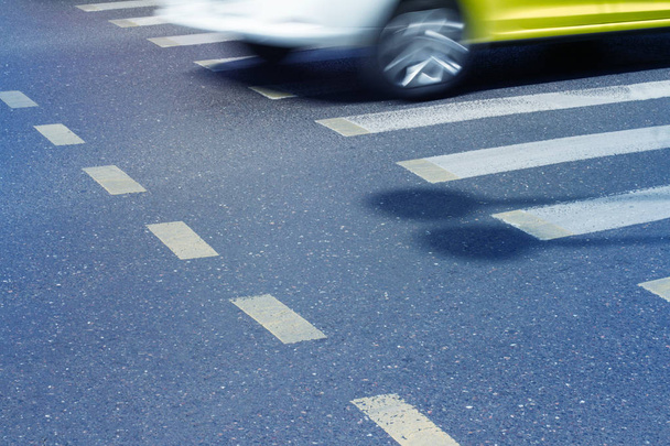 auto met motion blur tegenover een voetgangers kruising - Foto, afbeelding