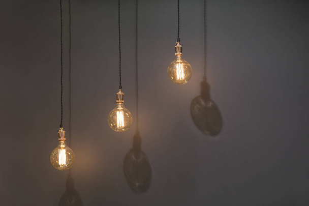 Three classic Edison lights bulb isolated on black background with space - Φωτογραφία, εικόνα