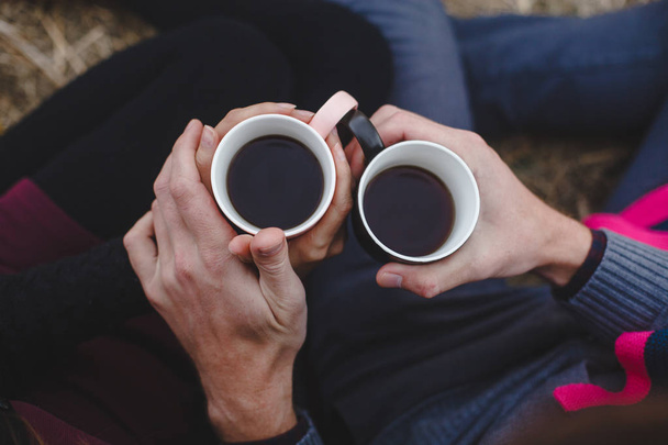 two cups of coffee in hand . A man's palm touches a woman's palm - Фото, изображение