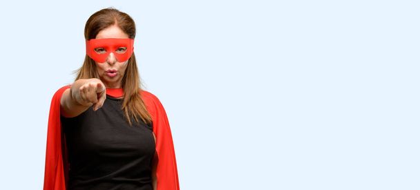Kırmızı maske ve parmak izole mavi arka plan ile ön işaret cape giyen orta yaş süper kahraman kadın - Fotoğraf, Görsel