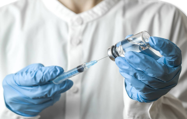 Hand holding syringe and vaccine. - Photo, Image