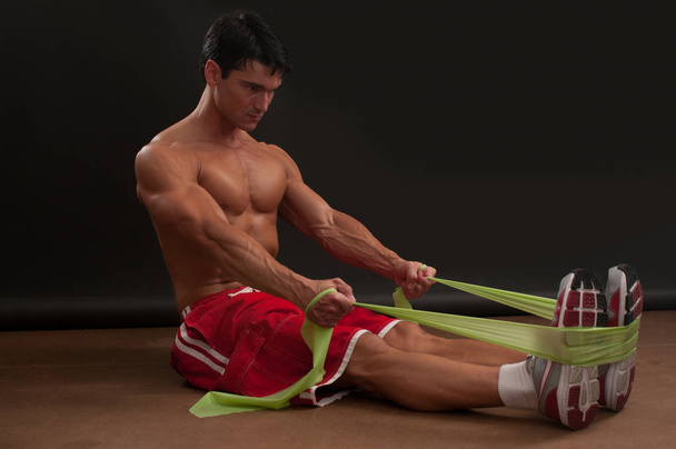 der gutaussehende Mann trainiert seine Muskeln. - Foto, Bild