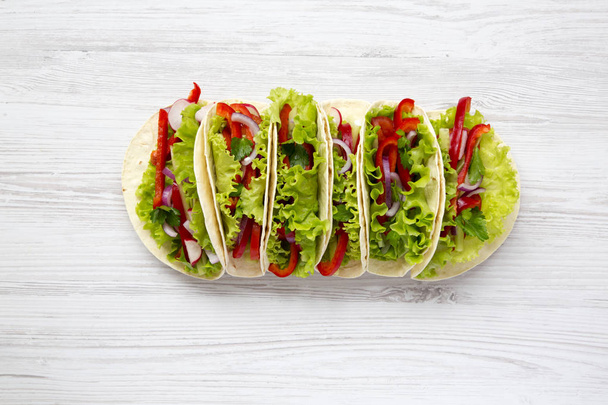Tacos wegetariańskie świeże na białym tle drewnianych. Z góry. Widok z góry - Zdjęcie, obraz