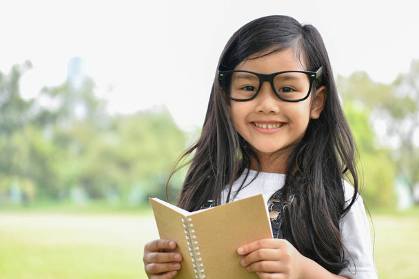 Onderwijs begrippen. Het meisje is het lezen van een boek in de tuin. Worden - Foto, afbeelding