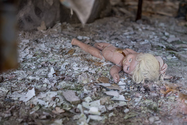 Abandoned kindergarten in Chernobyl Exclusion Zone. Lost toys, A broken doll. Atmosphere of fear and loneliness. Ukraine, ghost town Pripyat. - Foto, Imagen