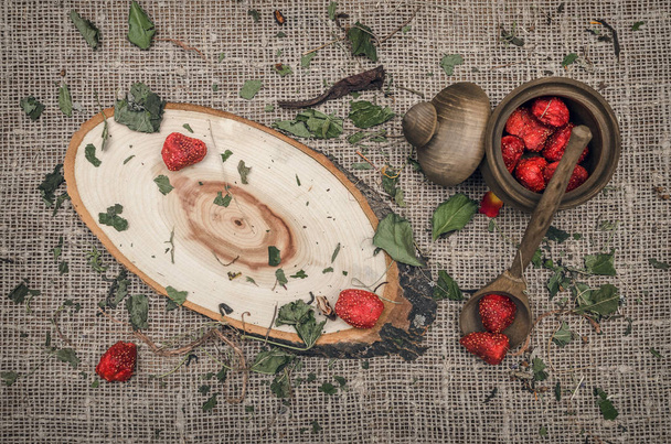 Herbal medicine concept. Dry strawberry in the jar on wooden brown table. Organic ingredients. - Fotografie, Obrázek
