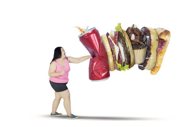 Asian obese woman punching unhealthy foods - Foto, Imagen