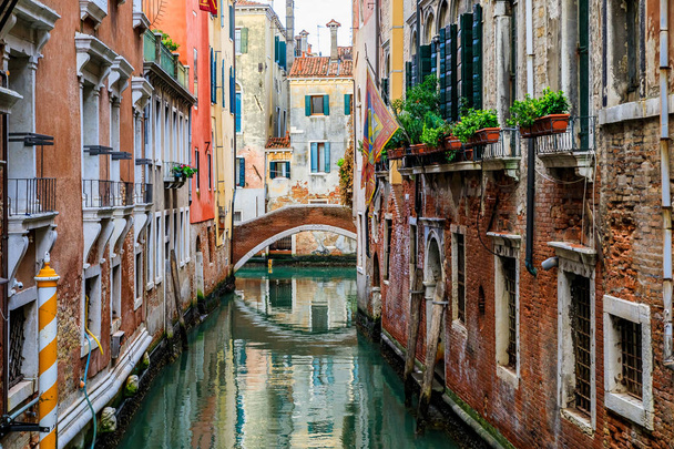 Погодный фасад здания на живописном канале в Венеции
 - Фото, изображение
