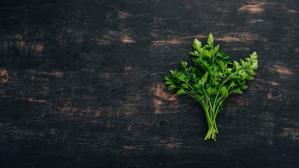 Parsley. Top view. On a black wooden background. Copy space. - Foto, imagen