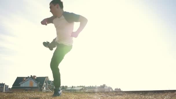 太陽の前にトレーニングの前にウォーム アップをしている若い manparkour トリッカー ジャンパー - 映像、動画