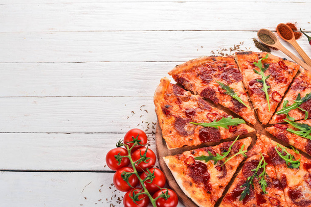 Pizza with chili and salami. Top view. On a wooden background. Copy space. - Фото, зображення