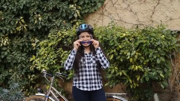 Joven ciclista femenina con gafas y un casco sonriendo y mirando a la cámara
 - Metraje, vídeo