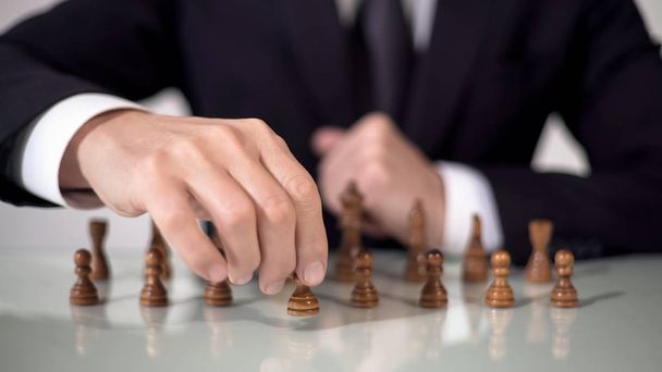 Male hand moving pawn in chess game, strategic start for successful project - Fotografie, Obrázek