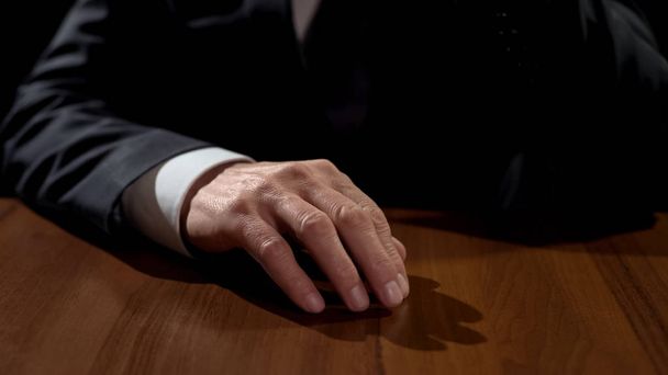 Closeup of hand on table, man thinking over serious decision, problem solution - 写真・画像