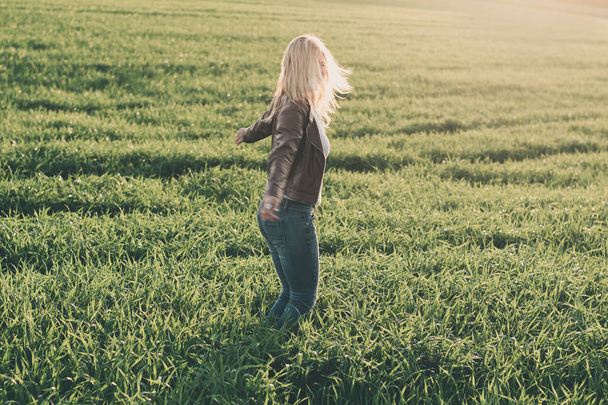 Счастливая женщина танцует на зеленом поле
. - Фото, изображение