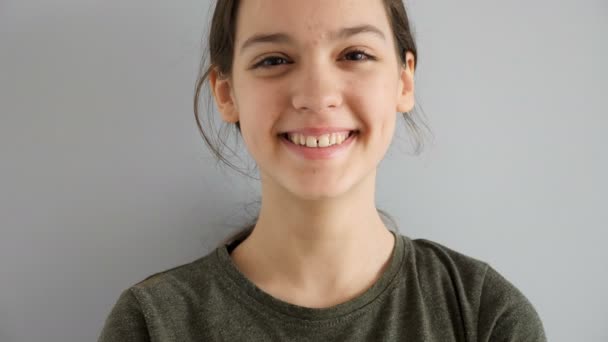Aranyos tizenéves lány nevetve naturaly szürke háttér portréja - Felvétel, videó