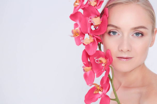 Young beauty woman with flower near face - Valokuva, kuva