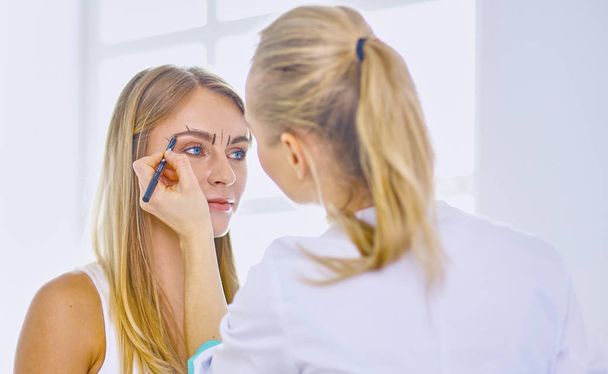 Permanent Makeup For Eyebrows. Beautiful Woman With Thick Brows In Beauty Salon. Beautician Doing Eyebrow Tattooing For Female Face. Beauty Procedure - Valokuva, kuva