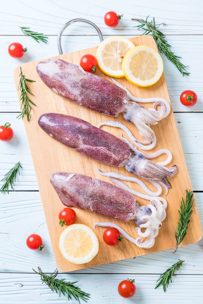 fresh octopus or squids raw on wooden board - Photo, image