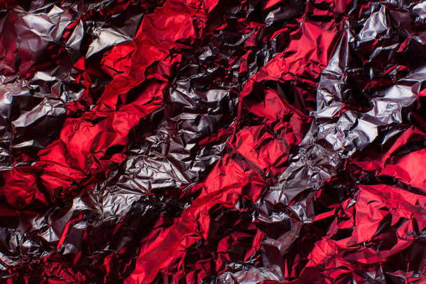 Holographic iridescent metallic foil. Real Hologram Background of wrinkled abstract foil 80s texture with multiple colors. red Burgundy with gray veins - Photo, Image