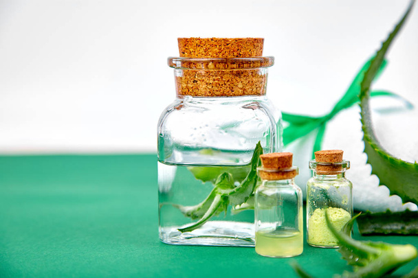 アロエベラ オイル ガラス瓶とタオルで緑の背景の上のスパ。つ星サボテン、反対側、Jafferabad、アロエ精製、皮膚の治療やケアのためのバルバドス漢方薬。コピー スペース - 写真・画像