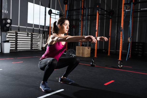 Athletic dziewczyna squat ćwiczeń na siłowni - Zdjęcie, obraz