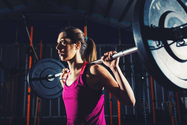 Athlétique fille travaille à la salle de gym avec un haltère
 - Photo, image