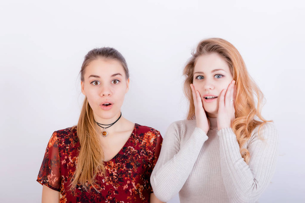 Two young beautiful girls look very surprised - Фото, изображение