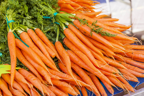 Fresh carrots are laid out on a show-window of the market - Photo, image