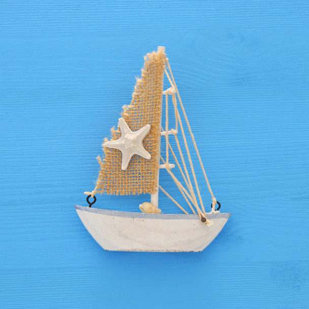 vacation and summer image with boat over blue wooden background. - Photo, Image