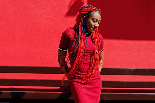 Cute and slim african american girl in red dress with dreadlocks - Foto, afbeelding