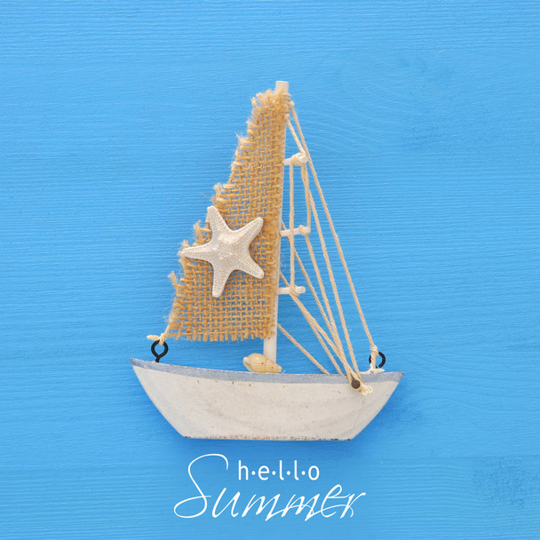 vacation and summer image with boat over blue wooden background. - Φωτογραφία, εικόνα
