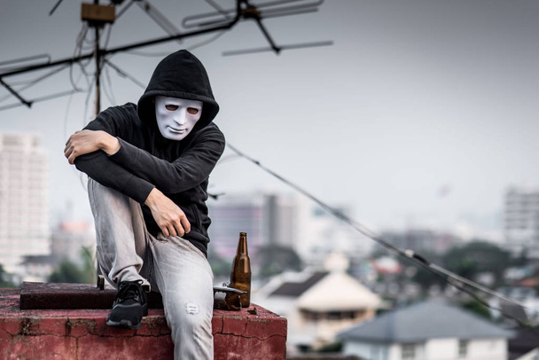 Boş ve kırık şişeyle oturan maskeli gizemli adam - Fotoğraf, Görsel