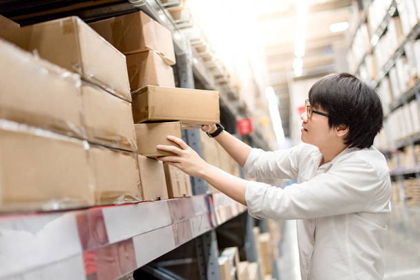 Jeune homme asiatique cueillette boîtes en papier dans l'entrepôt
 - Photo, image