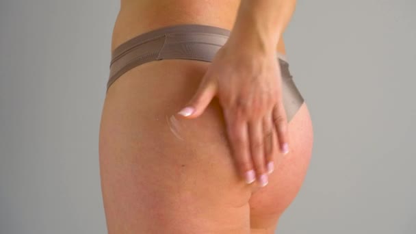 Vrouw wrijft in de huid van de billen en benen anticellulitis-crème - Video