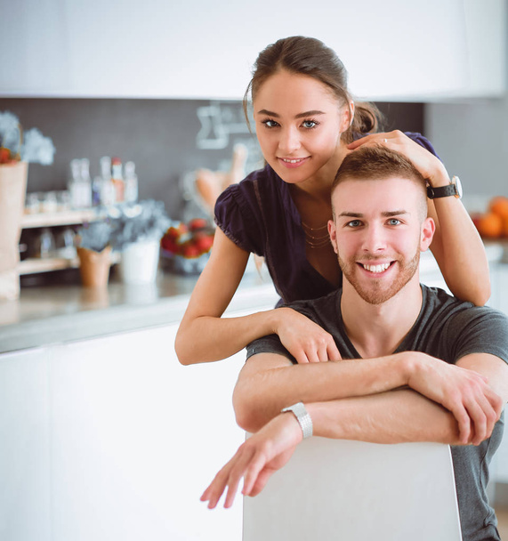 Beautiful young couple sitting in kitchen at home - Photo, Image