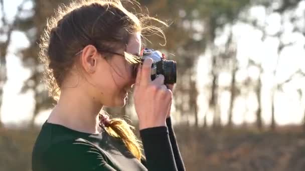 Hermosa chica toma fotos de su amado hombre en una cámara de cine
 - Metraje, vídeo