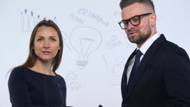 Homme et femme se serrent la main et discutent de la stratégie commerciale pour réussir dans un bureau en verre moderne
 - Séquence, vidéo