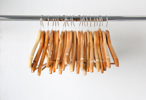 Clothes rail with wooden hangers on white background - Fotoğraf, Görsel
