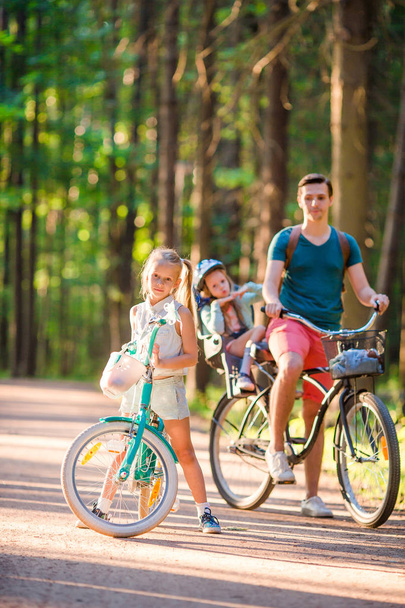 Onnellinen perhe pyöräily ulkona puistossa
 - Valokuva, kuva