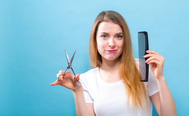 Woman with scissors and comb in salon hair cutting theme - Φωτογραφία, εικόνα