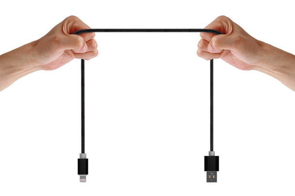 Cabo USB de telefone qualitativo preto nas mãos do homem isolado no fundo branco. Homem puxa o cabo para mostrar sua força e qualidade
 - Foto, Imagem