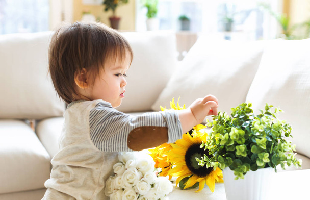 Happy toddler boy playing with flowers - Фото, зображення