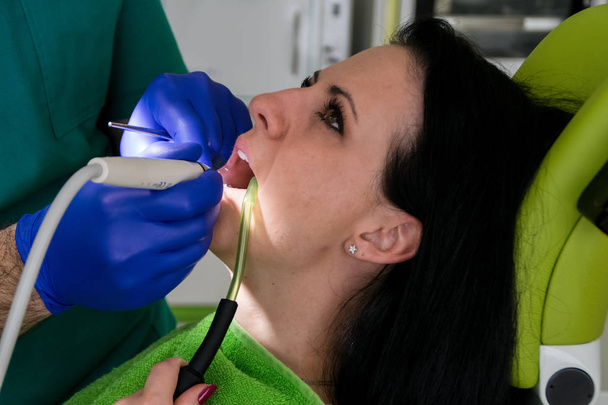  Diş hekimi diş kadın hastanın tamir ediyor. - Fotoğraf, Görsel