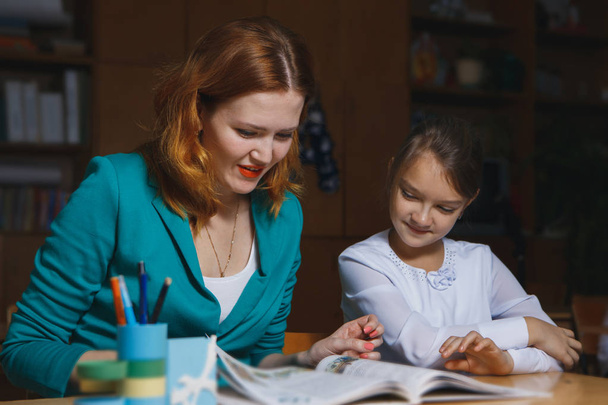 mother embracing daughter depressed about math homework - Foto, Bild