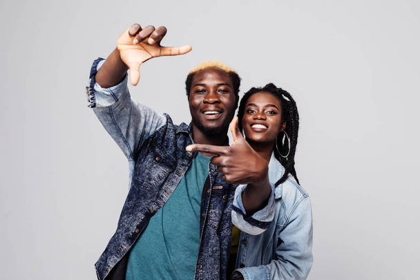 Portrait d'un heureux couple afro-américain faire un geste de cadre isolé sur blanc
 - Photo, image
