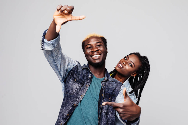 Retrato de um casal afro-americano feliz fazer gesto quadro isolado sobre branco
 - Foto, Imagem