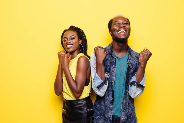 Muotokuva onnellinen nuori afro amerikkalainen pari huutaa ja juhlii eristetty yli keltainen
 - Valokuva, kuva