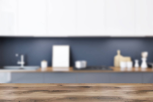 Gray kitchen countertops with built in appliances and a row of white cupboards hanging above them. A framed poster. 3d rendering mock up blurred - Foto, imagen