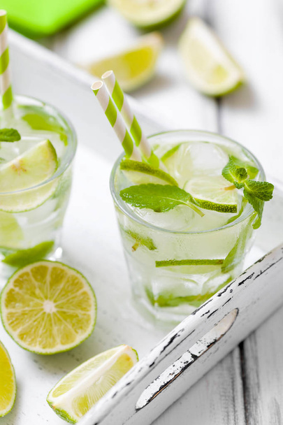 Summer refreshing cocktail caipirinha with lime and mint on white wooden vintage background. - Fotografie, Obrázek